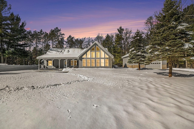 view of front of house with gravel driveway, covered porch, and a garage