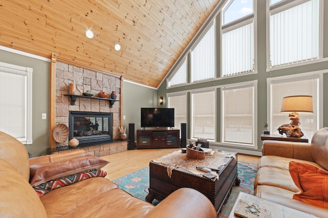 living area with high vaulted ceiling, wooden ceiling, a stone fireplace, and light wood finished floors