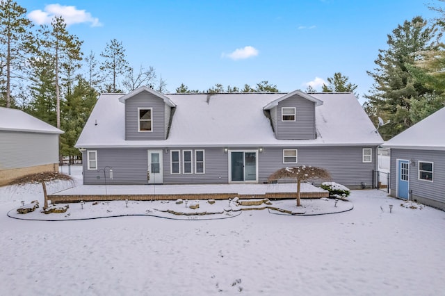 view of snow covered back of property