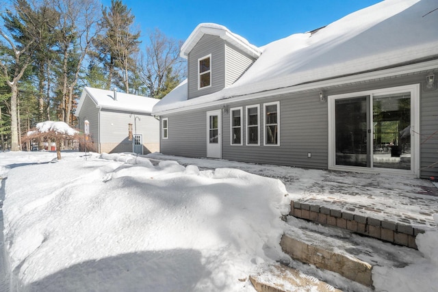 view of snow covered back of property