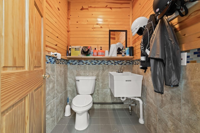 bathroom with toilet, a sink, and tile patterned floors