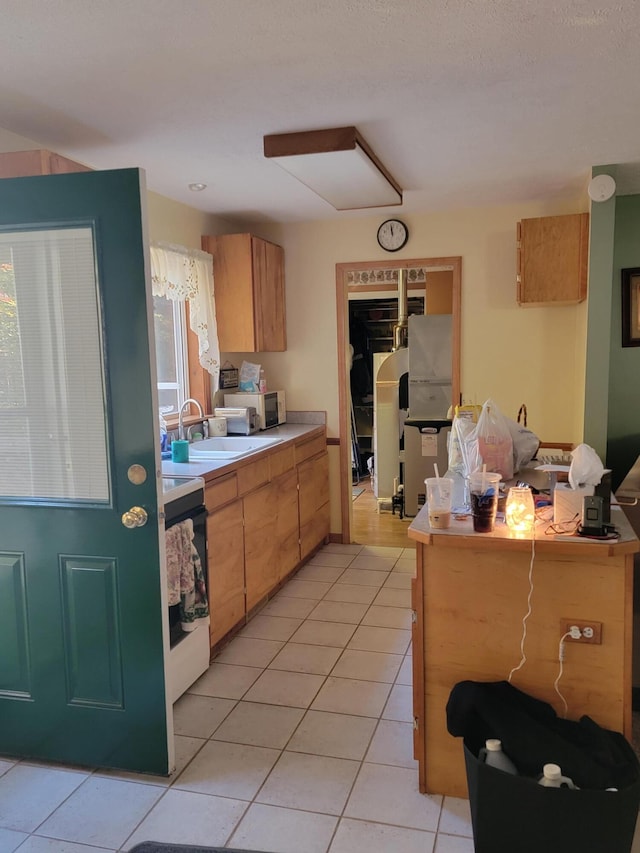 kitchen featuring kitchen peninsula, light tile patterned flooring, range, and sink