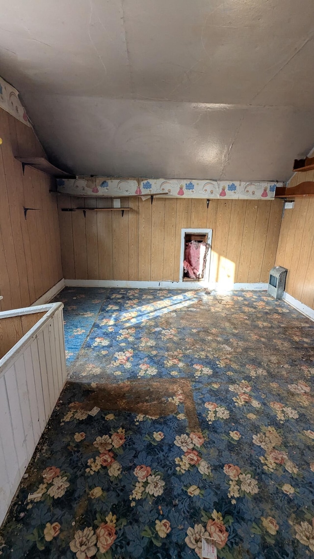 bonus room featuring wood walls and vaulted ceiling