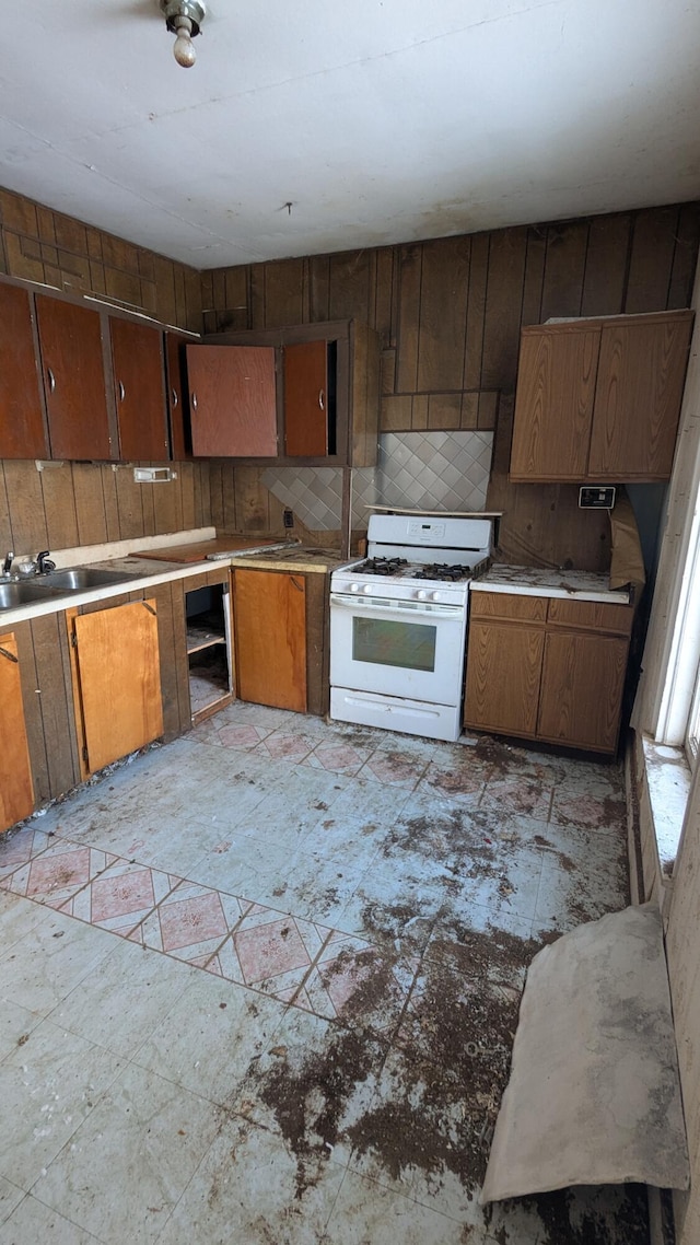 kitchen featuring sink, white range with gas cooktop, and tasteful backsplash