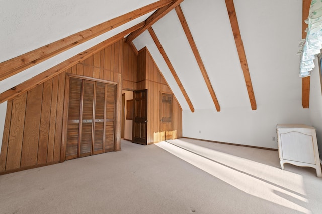 additional living space featuring wooden walls, beamed ceiling, light carpet, and high vaulted ceiling