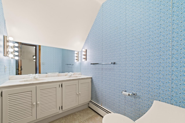 bathroom featuring vanity, a baseboard heating unit, vaulted ceiling, tile patterned flooring, and toilet