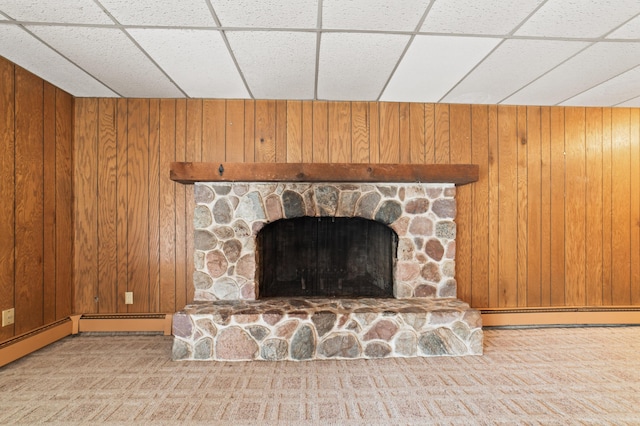 room details with a paneled ceiling, wooden walls, and a baseboard heating unit