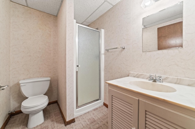 bathroom with a drop ceiling, toilet, an enclosed shower, and vanity