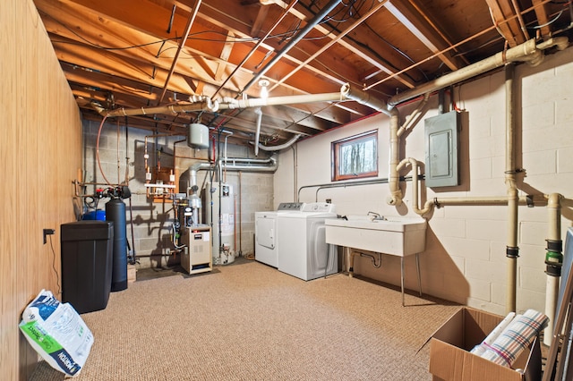 basement with electric panel, gas water heater, sink, carpet flooring, and washing machine and dryer