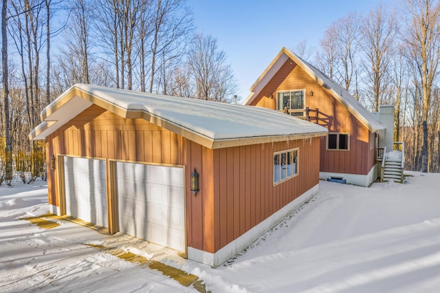 snow covered property with a garage