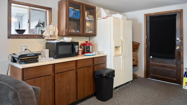 kitchen with dark colored carpet and white refrigerator with ice dispenser