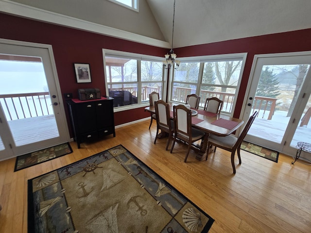 dining room featuring a wealth of natural light, light wood-type flooring, and a notable chandelier