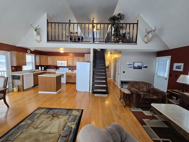 living room featuring light hardwood / wood-style floors, sink, and high vaulted ceiling