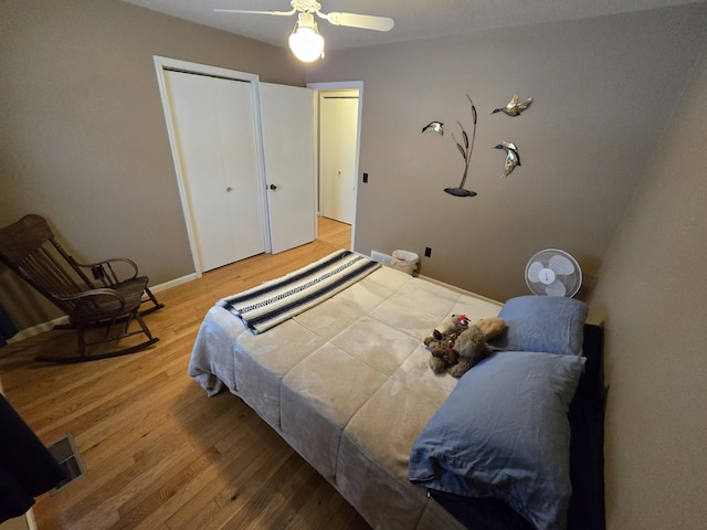 bedroom with hardwood / wood-style floors, ceiling fan, and a closet