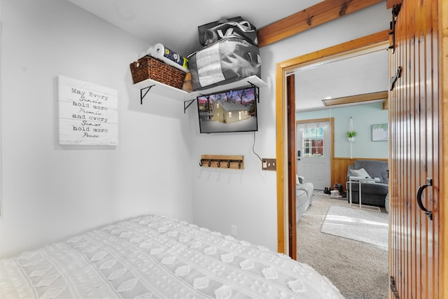 bedroom featuring wooden walls and carpet flooring