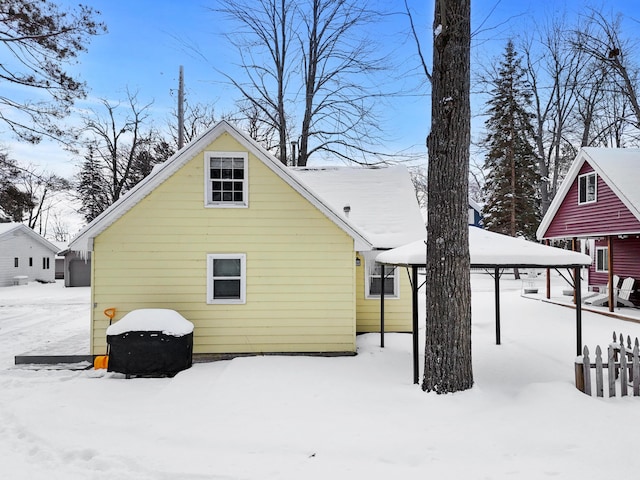 view of snow covered back of property