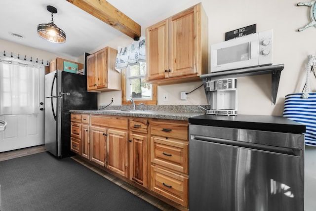 kitchen featuring decorative light fixtures, sink, appliances with stainless steel finishes, and beamed ceiling