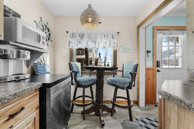 interior space featuring wood-type flooring, light brown cabinets, and hanging light fixtures