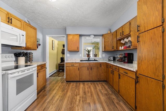 kitchen with white appliances, sink, a textured ceiling, baseboard heating, and dark hardwood / wood-style flooring