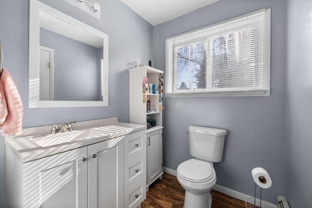 bathroom with hardwood / wood-style flooring, vanity, toilet, and a baseboard heating unit