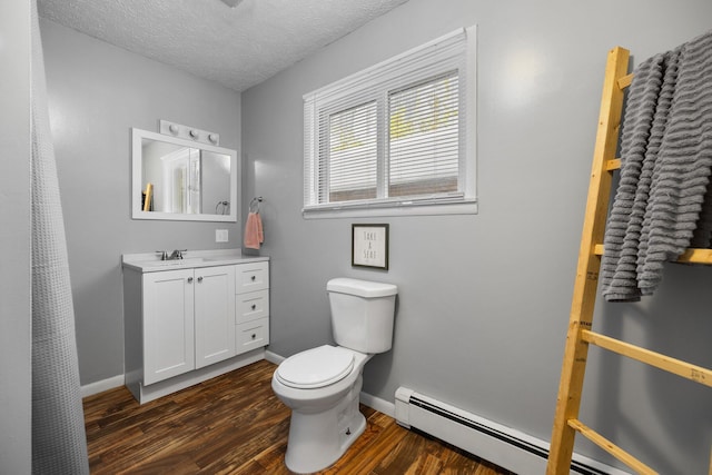 bathroom with vanity, a textured ceiling, hardwood / wood-style flooring, a baseboard radiator, and toilet