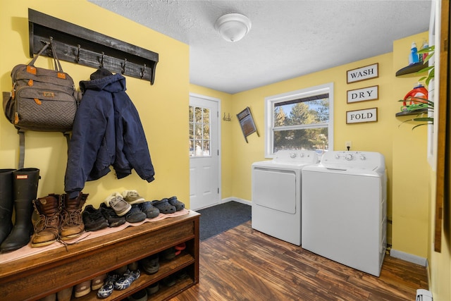 clothes washing area with a textured ceiling, separate washer and dryer, and dark wood-type flooring