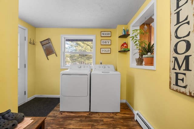 laundry room with dark hardwood / wood-style floors, a textured ceiling, a baseboard radiator, and washing machine and clothes dryer