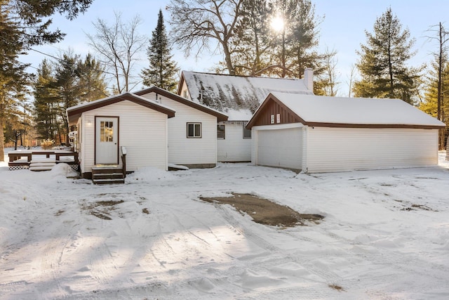 view of front of home featuring a garage and an outbuilding