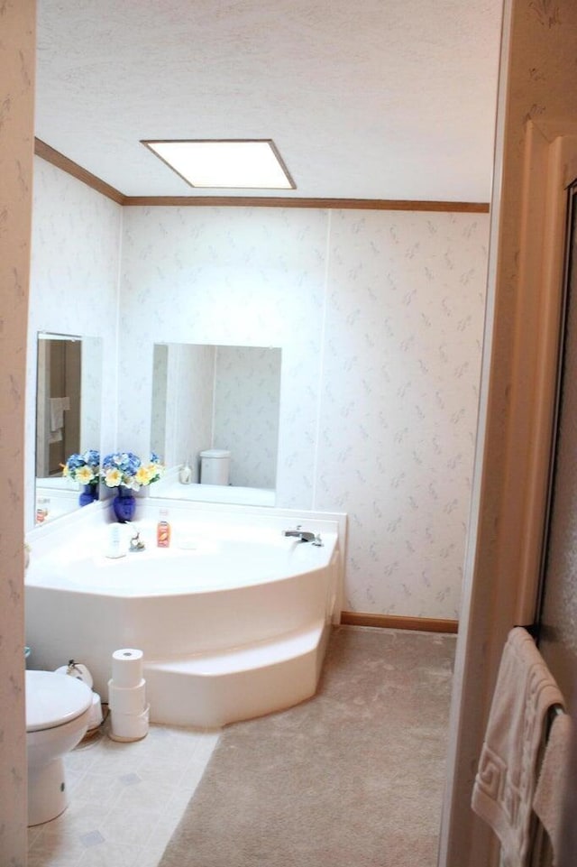 bathroom featuring toilet, a textured ceiling, and ornamental molding