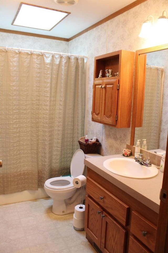 bathroom with vanity, toilet, crown molding, and walk in shower