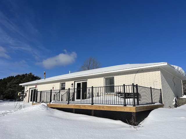 snow covered property with a deck