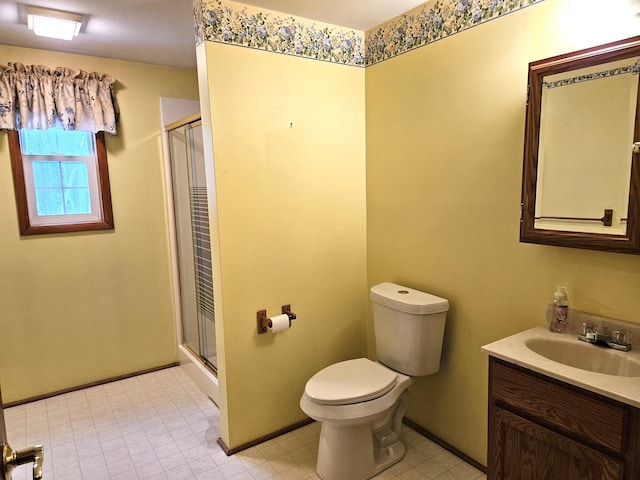 bathroom featuring a shower with door, toilet, and vanity