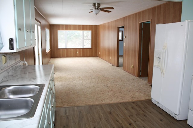 kitchen featuring white refrigerator with ice dispenser, dark carpet, ceiling fan, and sink