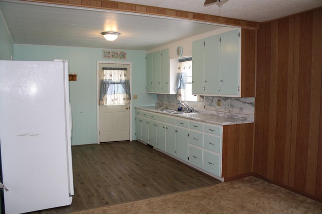 kitchen featuring dark colored carpet, white fridge, plenty of natural light, and sink