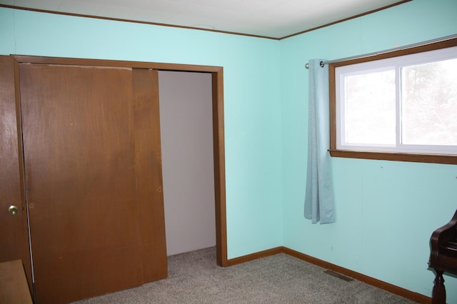 unfurnished bedroom with light carpet and a closet