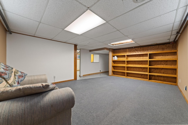 basement with a paneled ceiling and carpet floors