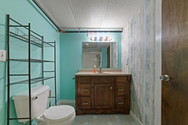 bathroom with vanity, toilet, and a drop ceiling