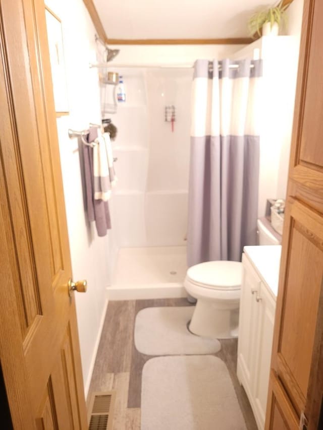 bathroom featuring hardwood / wood-style flooring, vanity, toilet, and a shower with shower curtain