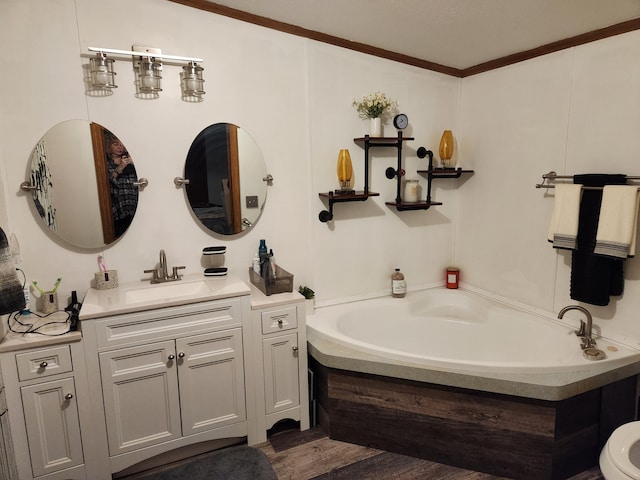 bathroom with vanity, ornamental molding, and a tub to relax in