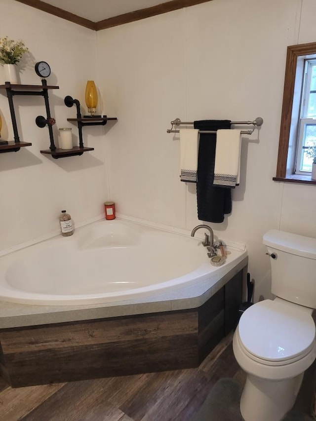 bathroom featuring wood-type flooring, a tub to relax in, and toilet