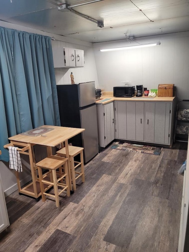 kitchen with dark wood-type flooring and stainless steel fridge