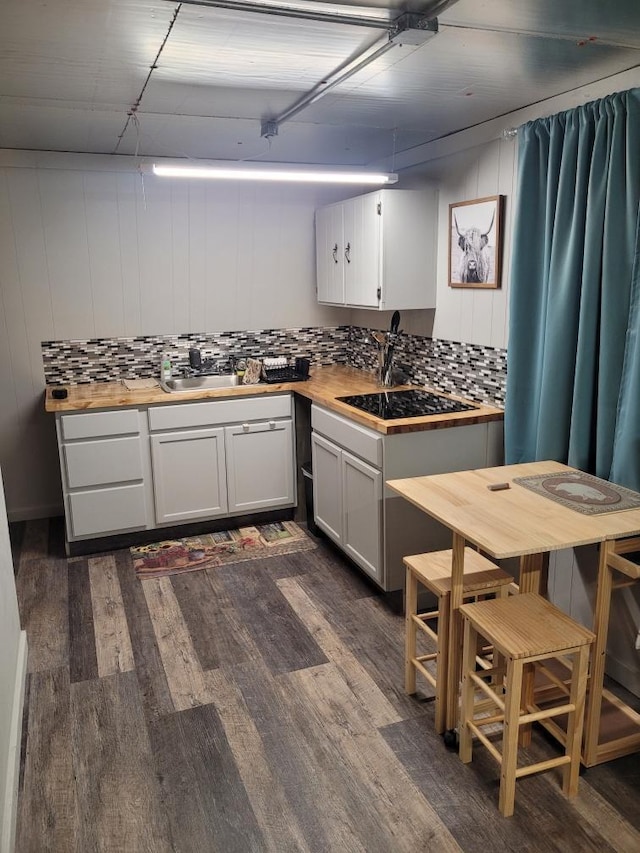 kitchen with white cabinetry, butcher block counters, and sink