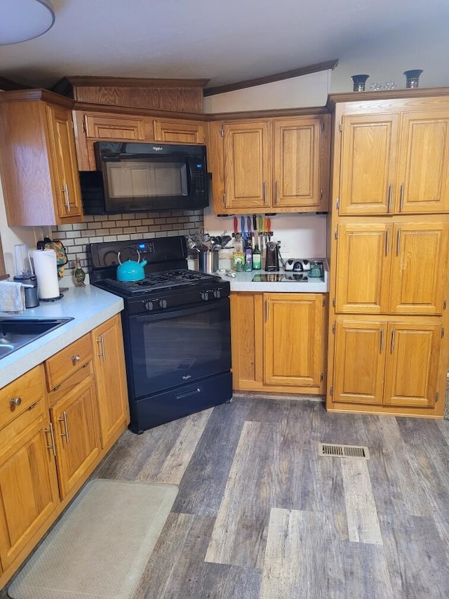 kitchen featuring dark hardwood / wood-style floors, sink, and black appliances