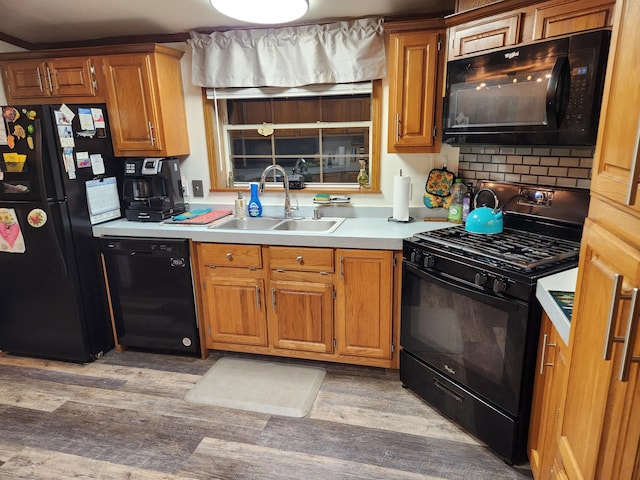 kitchen with light wood-type flooring, sink, and black appliances