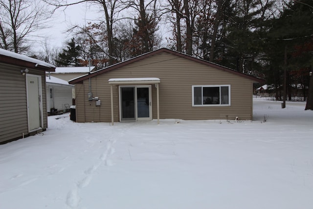 view of snow covered back of property