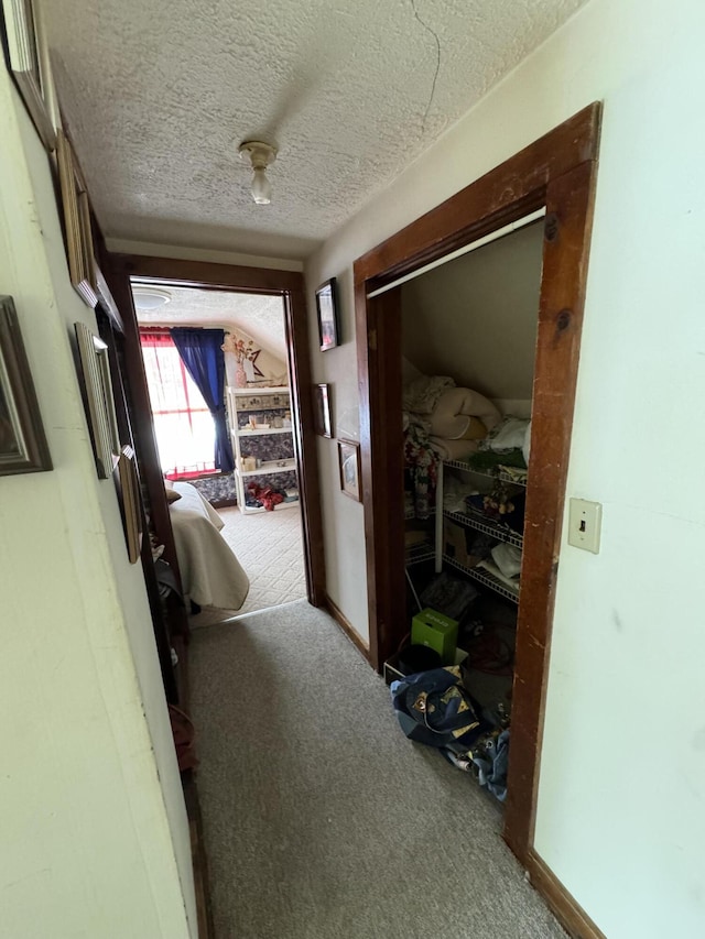 hallway featuring a textured ceiling and carpet floors