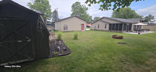 view of yard with a fire pit, a storage unit, and a patio