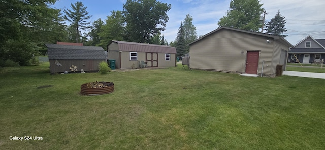 view of yard with a fire pit and a storage shed