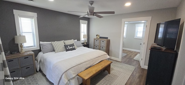 bedroom with multiple windows, ceiling fan, and dark hardwood / wood-style floors