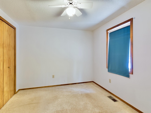 interior space with ceiling fan and light carpet